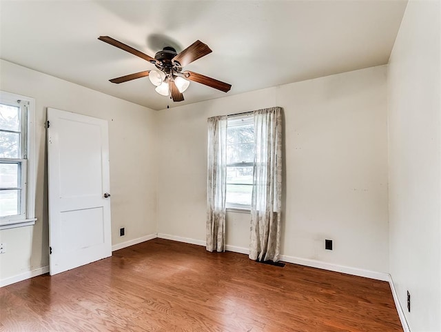 unfurnished room with a ceiling fan, baseboards, and wood finished floors