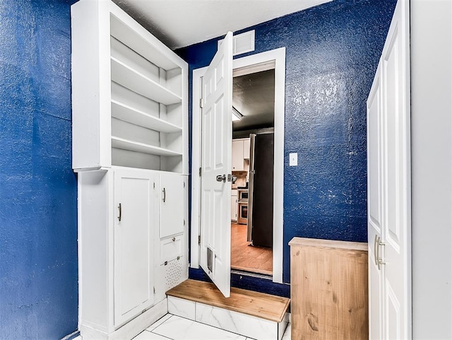 unfurnished bedroom with visible vents and a textured wall