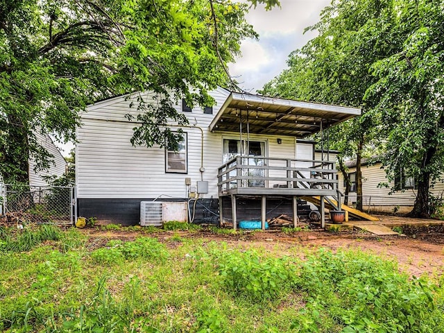 back of property with fence, a wooden deck, stairs, and central AC unit