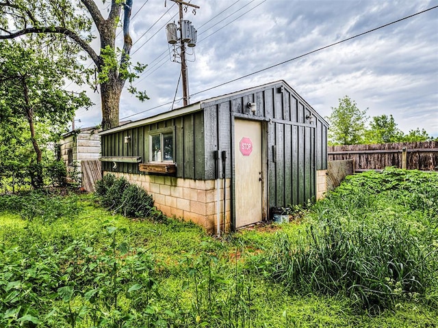 view of outbuilding featuring fence and an outdoor structure