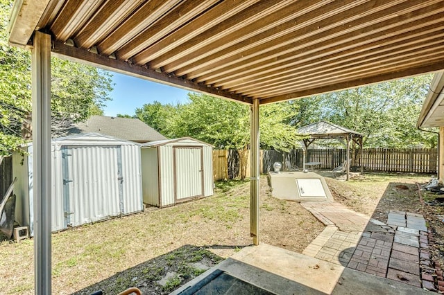 view of yard with a storage unit, a fenced backyard, an outdoor structure, and a gazebo