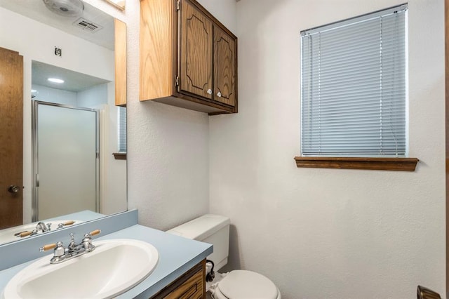 full bath featuring toilet, visible vents, a shower stall, and vanity
