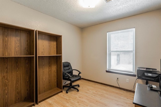 office space featuring a textured ceiling and light wood-style flooring