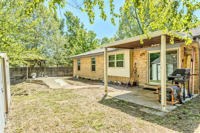 back of house with a lawn, brick siding, and fence