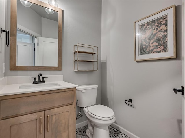 bathroom with toilet, baseboards, and vanity