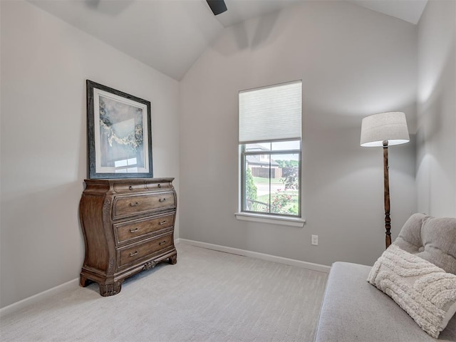 living area featuring baseboards, a ceiling fan, light colored carpet, and lofted ceiling