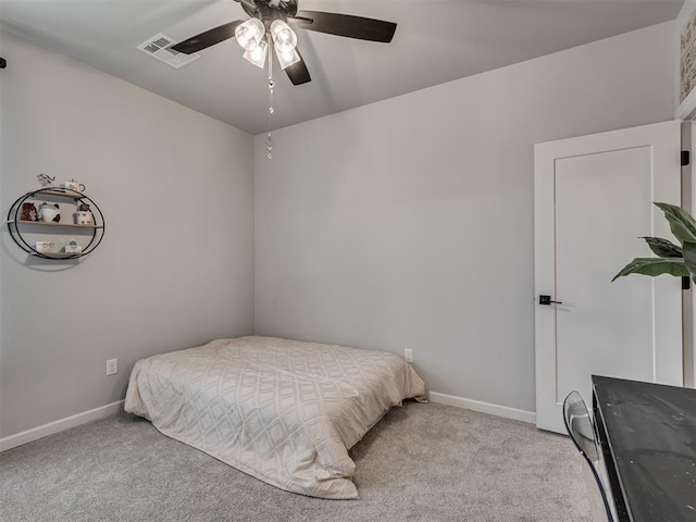 bedroom featuring baseboards, light carpet, a ceiling fan, and visible vents