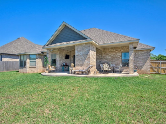 back of house with a yard, brick siding, a fenced backyard, and a patio area