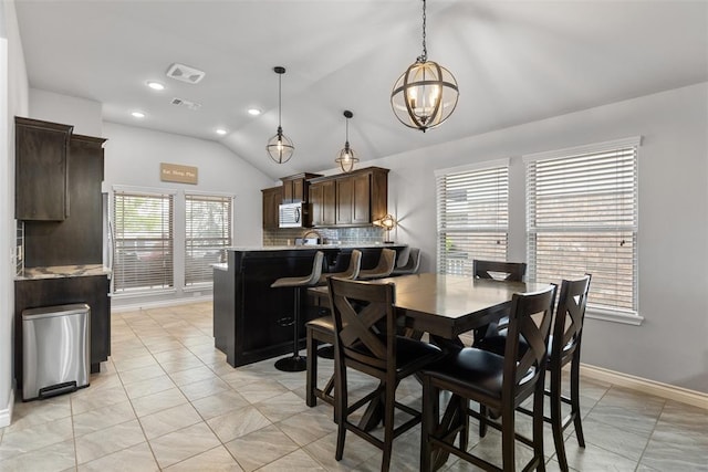 dining room featuring a chandelier, recessed lighting, baseboards, light tile patterned floors, and vaulted ceiling