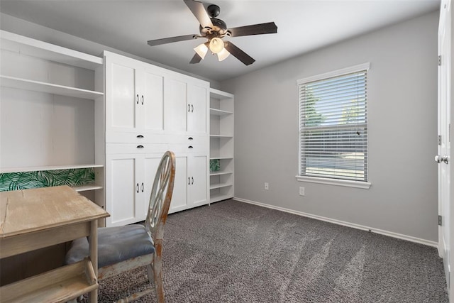 office area featuring dark colored carpet, baseboards, and ceiling fan