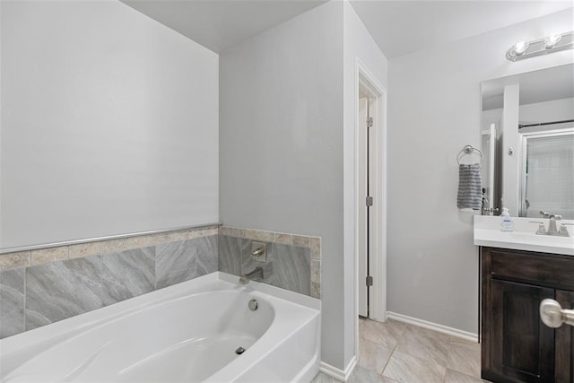 full bath featuring vanity, baseboards, and a garden tub