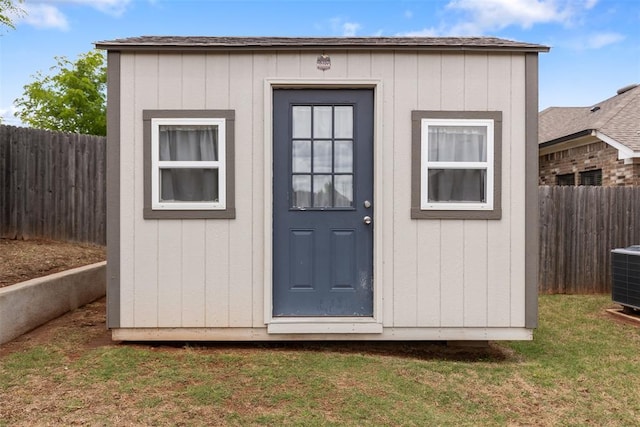view of shed with a fenced backyard and central AC unit