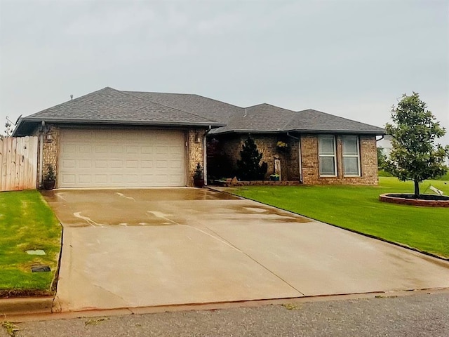 107 Chuckwagon Way, Elk City, OK 73644 - view of front of home featuring a front yard, brick siding, fence, concrete driveway, and an attached garage