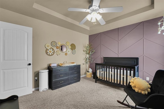 107 Chuckwagon Way, Elk City, OK 73644 - bedroom featuring ceiling fan, a raised ceiling, baseboards, a crib, and carpet flooring