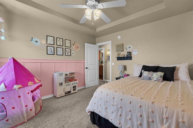 107 Chuckwagon Way, Elk City, OK 73644 - carpeted bedroom featuring a tray ceiling, wainscoting, and ceiling fan