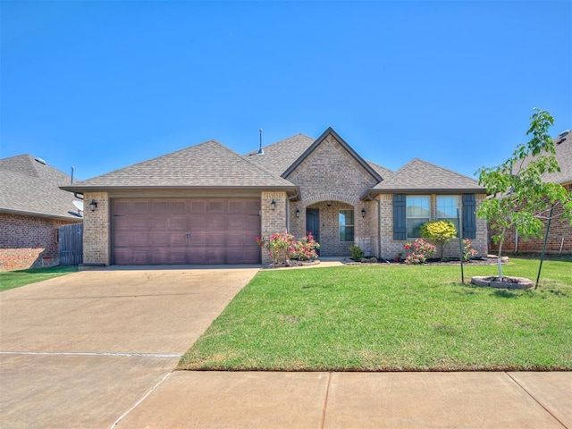view of front facade with a garage, a front lawn, brick siding, a shingled roof, and concrete driveway