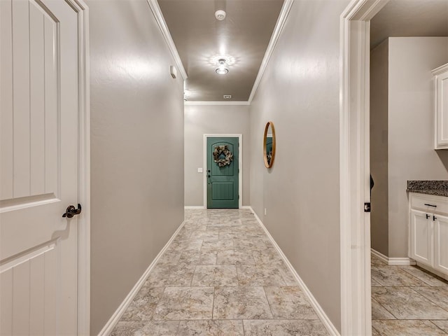 corridor with crown molding, baseboards, and stone finish flooring