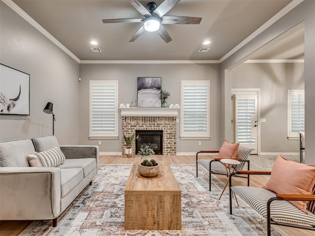 living room with a ceiling fan, a brick fireplace, baseboards, light wood-style floors, and recessed lighting