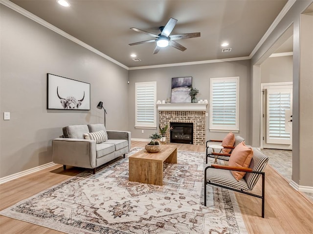 living room featuring a brick fireplace, a ceiling fan, baseboards, recessed lighting, and wood finished floors