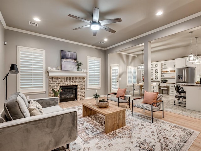 living room with light wood-style floors, ceiling fan, ornamental molding, and recessed lighting