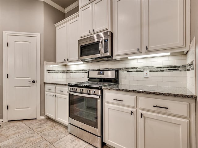 kitchen featuring crown molding, dark stone countertops, appliances with stainless steel finishes, and backsplash