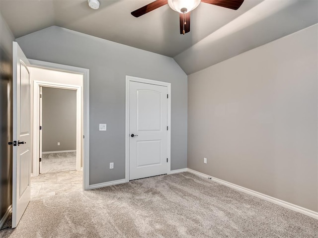 unfurnished bedroom with baseboards, ceiling fan, carpet, and vaulted ceiling