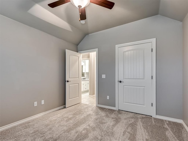 unfurnished bedroom with light colored carpet, baseboards, ceiling fan, and lofted ceiling