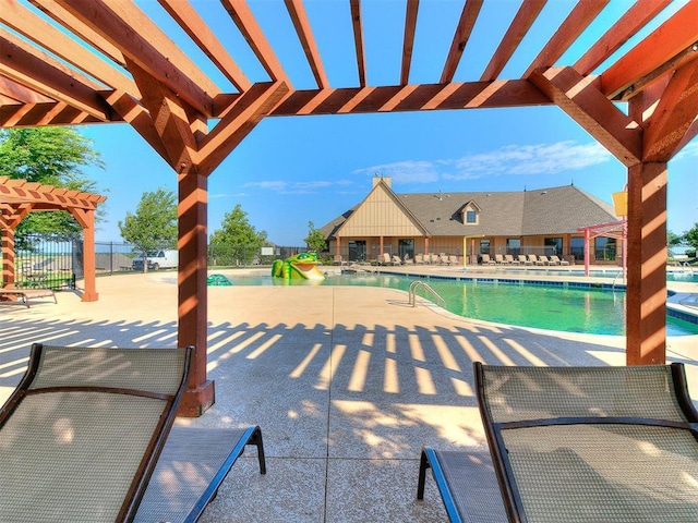 community pool with fence, a pergola, a water slide, and a patio