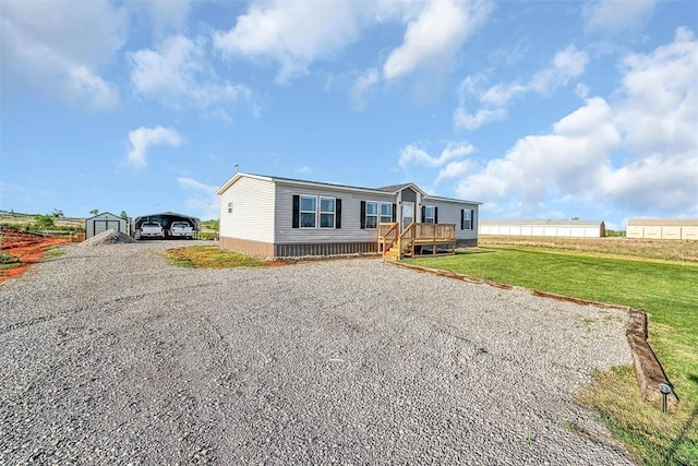 10284 N 2128, Foss, OK 73647 - manufactured / mobile home with driveway, a detached carport, a deck, and a front yard