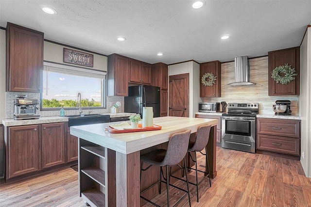 10284 N 2128, Foss, OK 73647 - kitchen featuring stainless steel electric range oven, wall chimney exhaust hood, freestanding refrigerator, backsplash, and recessed lighting
