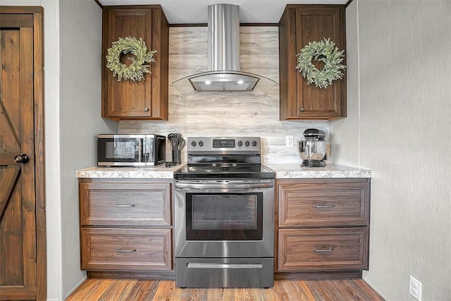 10284 N 2128, Foss, OK 73647 - kitchen featuring stainless steel appliances, island exhaust hood, light countertops, wood finished floors, and decorative backsplash