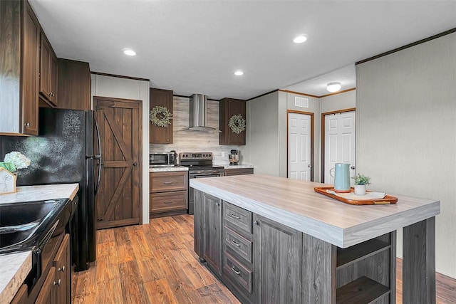 10284 N 2128, Foss, OK 73647 - kitchen featuring wall chimney range hood, electric stove, wood finished floors, light countertops, and tasteful backsplash