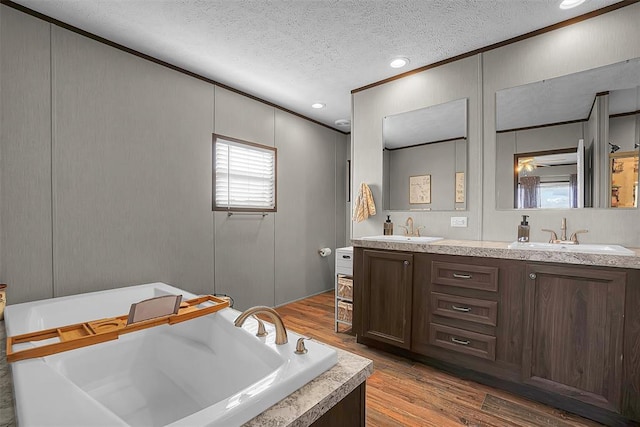 10284 N 2128, Foss, OK 73647 - full bath featuring a textured ceiling, a freestanding tub, a decorative wall, crown molding, and wood finished floors