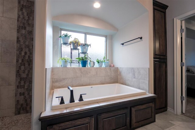 full bath with a garden tub and tiled shower
