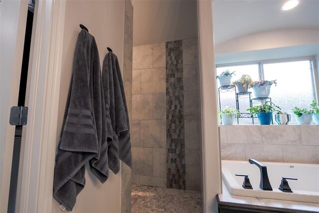 bathroom with a bath, walk in shower, and vaulted ceiling