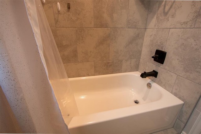 bathroom with a tub and a shower with shower curtain