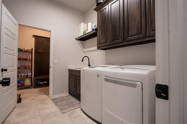 laundry room with cabinet space, washing machine and clothes dryer, and light tile patterned floors