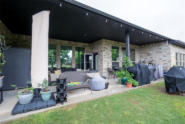 rear view of house featuring a patio area, brick siding, and a yard