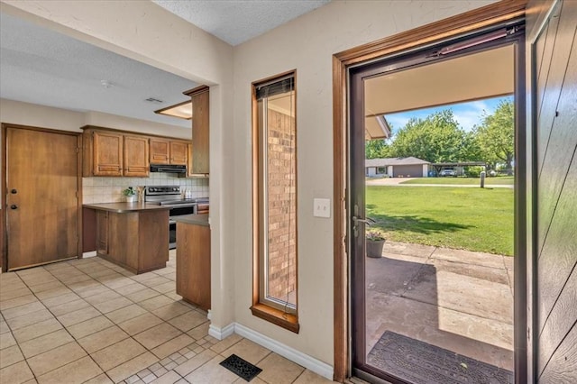 entryway featuring baseboards, a textured ceiling, and light tile patterned flooring