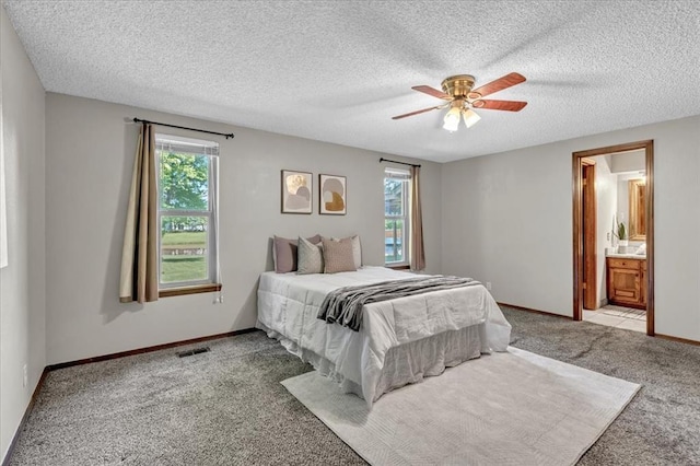 bedroom with baseboards, carpet flooring, a textured ceiling, and visible vents