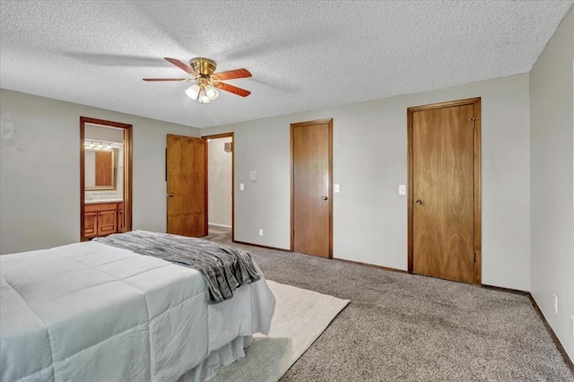 bedroom featuring a ceiling fan, a textured ceiling, baseboards, multiple closets, and carpet