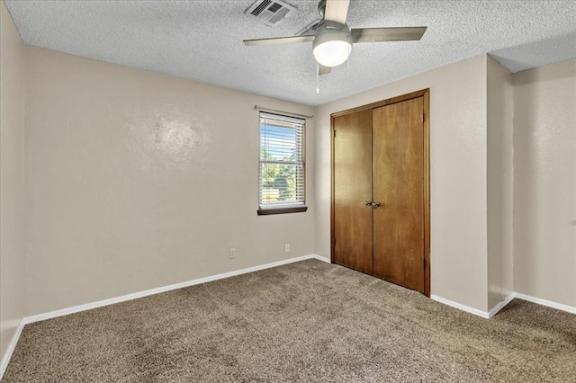 unfurnished bedroom featuring carpet floors, a textured ceiling, and visible vents