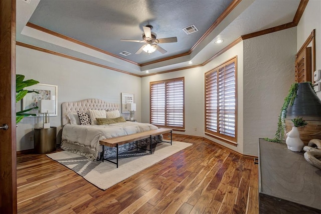 4495 SE 37th St, Norman, OK 73072 - bedroom with ornamental molding, a tray ceiling, wood finished floors, a textured wall, and a ceiling fan