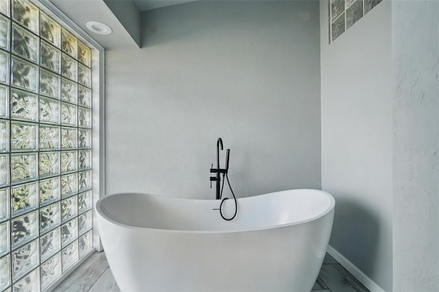 3408 Partridge Rd, Oklahoma City, OK 73120 - full bathroom featuring a healthy amount of sunlight, a freestanding tub, and baseboards