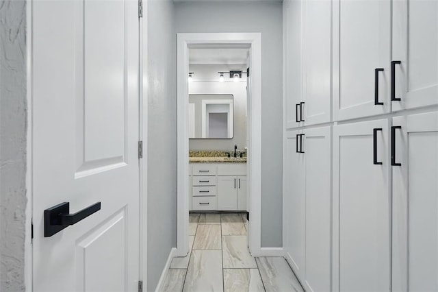 3408 Partridge Rd, Oklahoma City, OK 73120 - corridor featuring baseboards, a sink, and marble finish floor