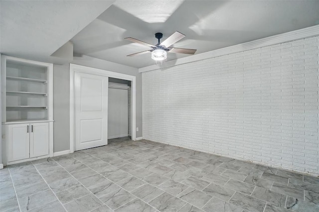 3408 Partridge Rd, Oklahoma City, OK 73120 - unfurnished bedroom featuring baseboards, a ceiling fan, a closet, and brick wall