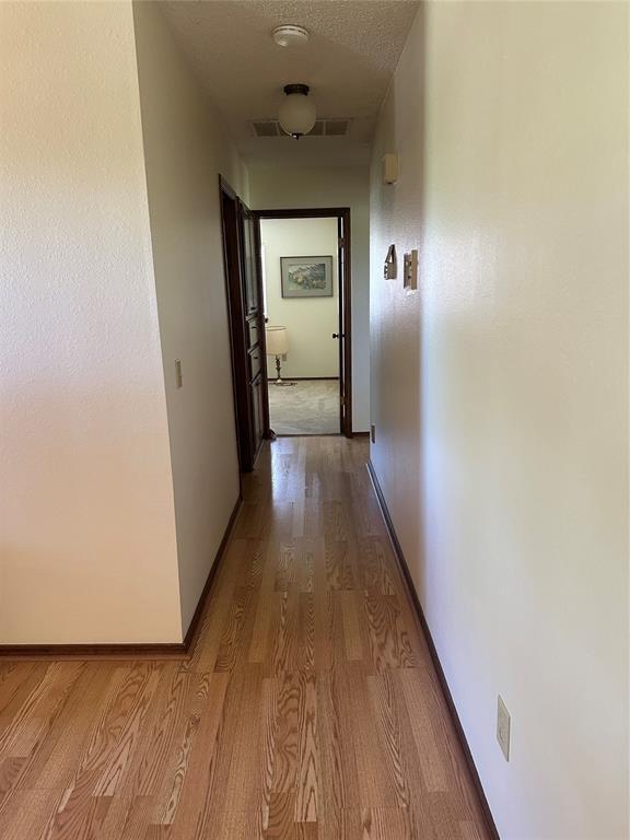 1721 E Ridgeview Ter, Mustang, OK 73064 - corridor featuring baseboards and wood finished floors