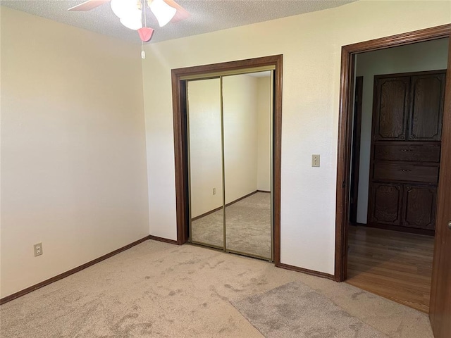 1721 E Ridgeview Ter, Mustang, OK 73064 - unfurnished bedroom featuring a closet, a textured ceiling, baseboards, and light carpet