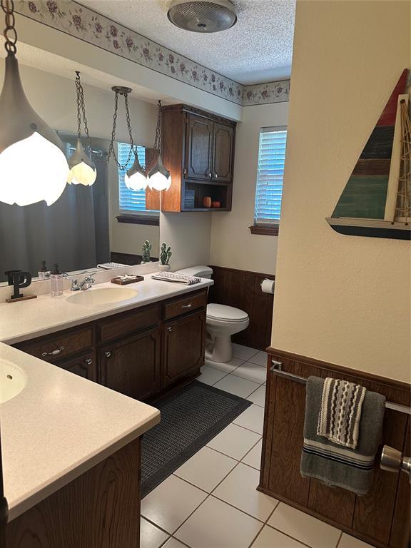 1721 E Ridgeview Ter, Mustang, OK 73064 - full bath with vanity, a wainscoted wall, a healthy amount of sunlight, and toilet