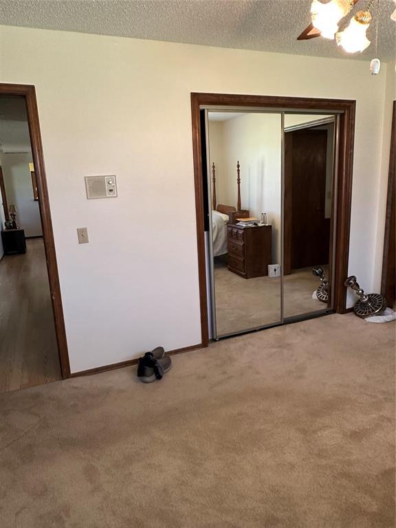1721 E Ridgeview Ter, Mustang, OK 73064 - carpeted bedroom featuring a closet, a ceiling fan, a textured ceiling, and baseboards